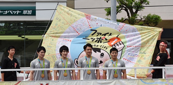 市内小学校の生徒が応援メッセージを書き込んだよさこい旗と選手達の画像