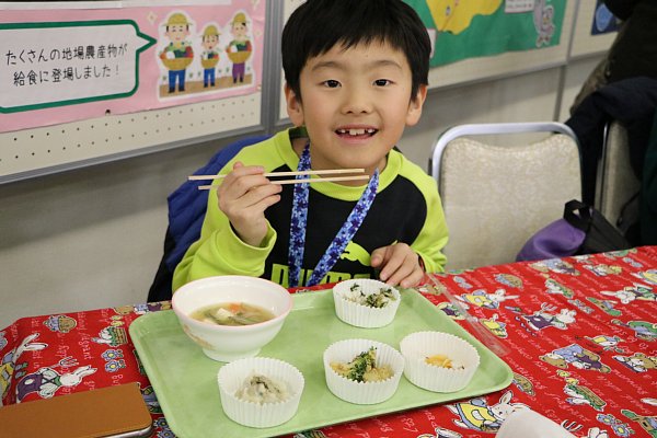 試食給食を食べる子供の写真