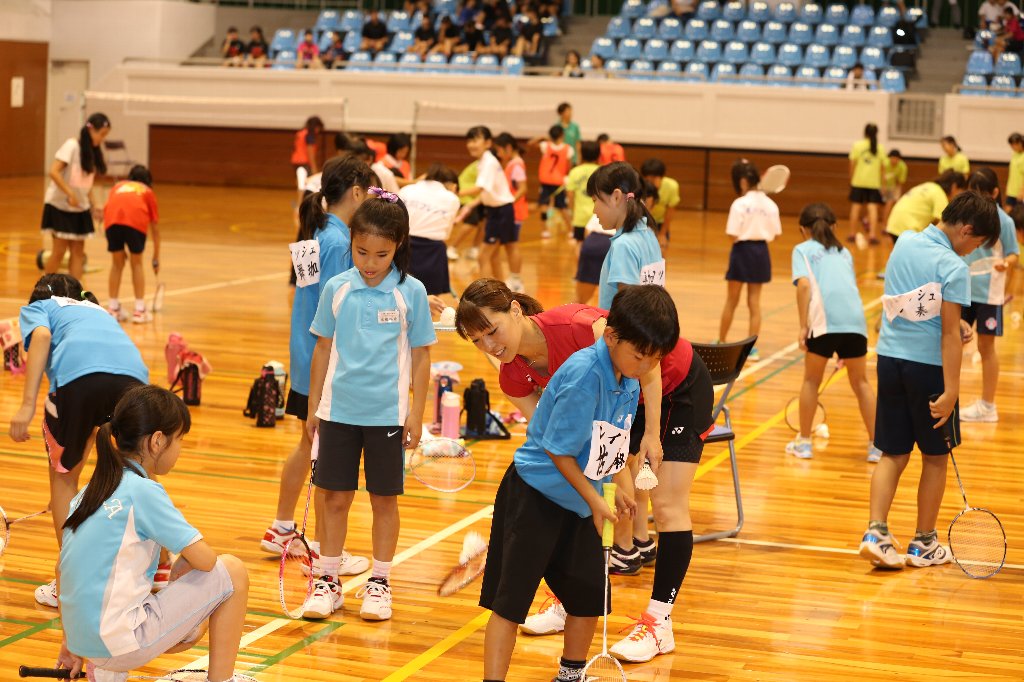 選手にバトミントンを教わる子供達の画像