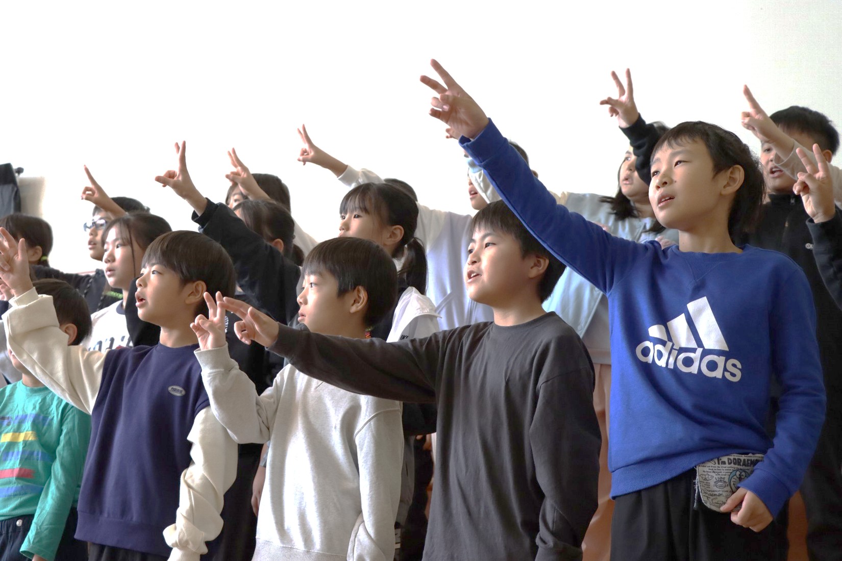 手話を付けて合唱する児童たちの画像