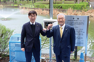 装置とボードの前で浅井昌志市長、中村孝明会長の写真