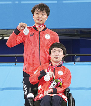Smiling Mr. Takahashi, with the silver medal (front) and Mr. Taoda, assistant (back)
